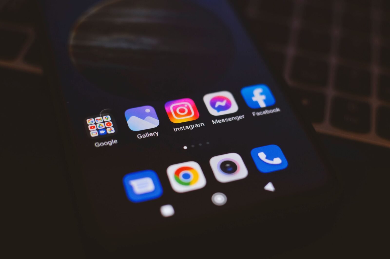A smartphone displaying popular social media apps in a dimly lit environment, perfect for tech and communication themes.