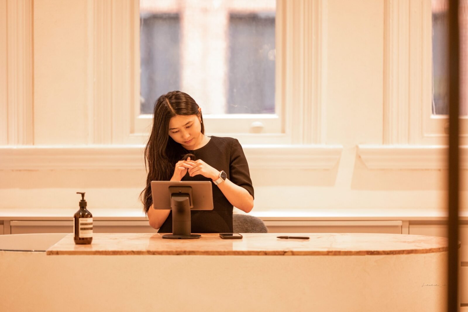 Young woman in office working on a tablet. Modern technology at a stylish workspace.
