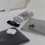 A sleek arrangement of high-tech gadgets and dollar bills on a minimalist desk.