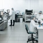 Researchers in lab coats performing experiments with advanced equipment in a laboratory.